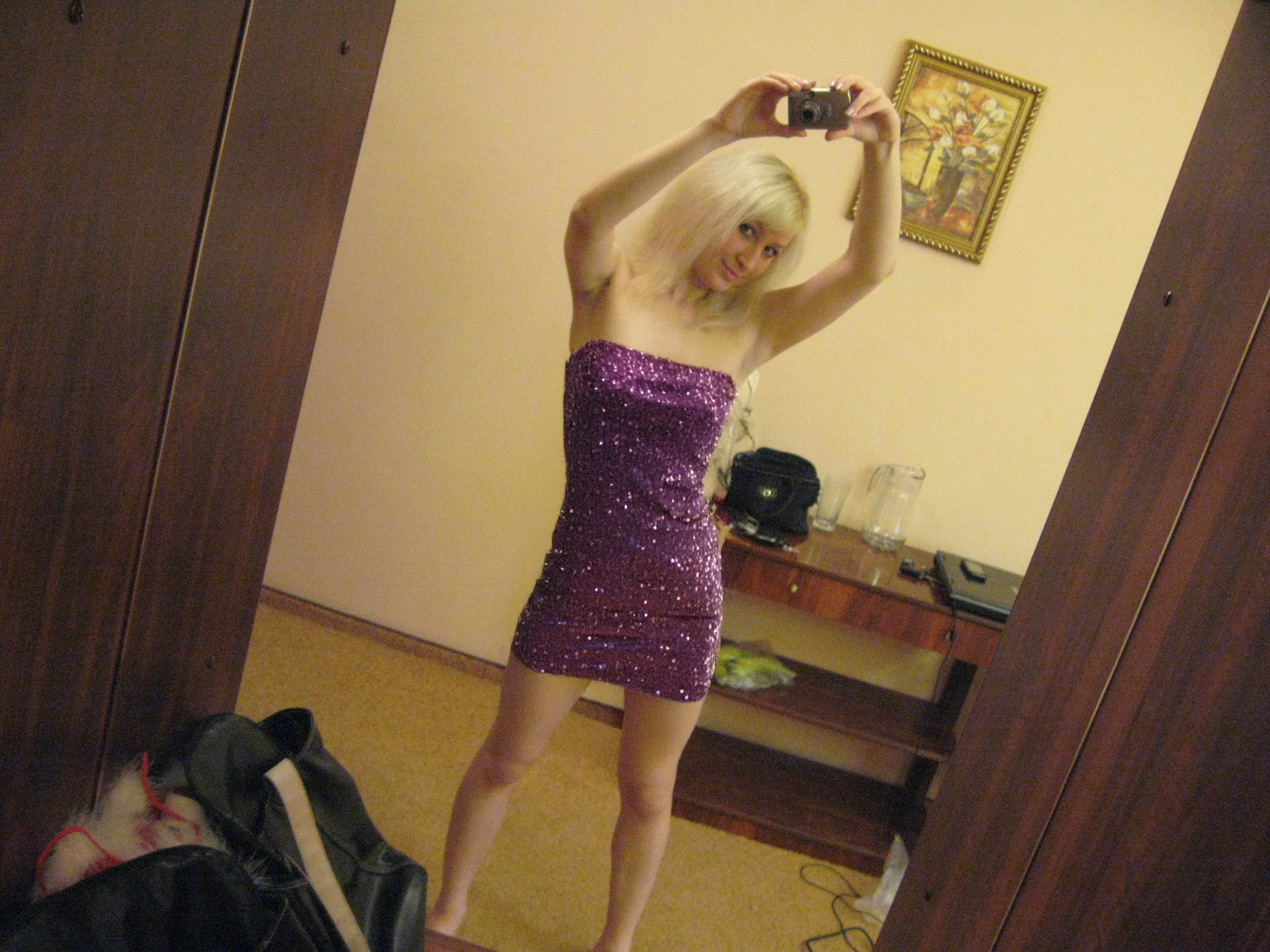 blonde girl takes a picture of herself completely naked in the mirror